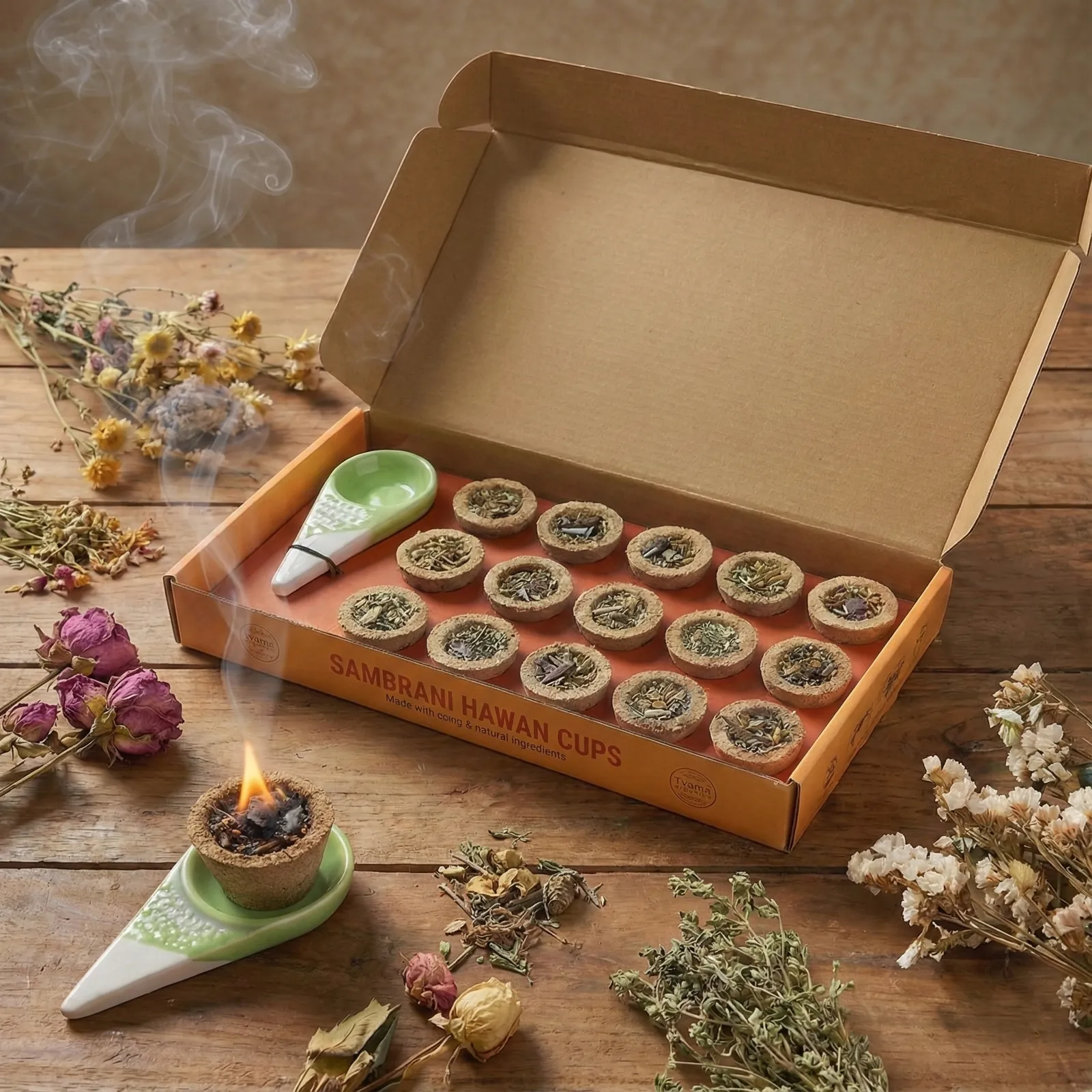 An open box of Sambrani hawan cups, one lit on its ceramic stand